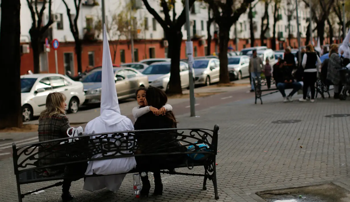 Orang berpakain capirote saat mengikuti prosesi Pekan Suci atau Semana Santa di ibukota Andalusia, Spanyol, (21/3). Mengikuti prosesi Semana Santa merupakan sarana menjalani penitensi atau hukuman dari dosa-dosa. (REUTERS / Marcelo del Pozo)