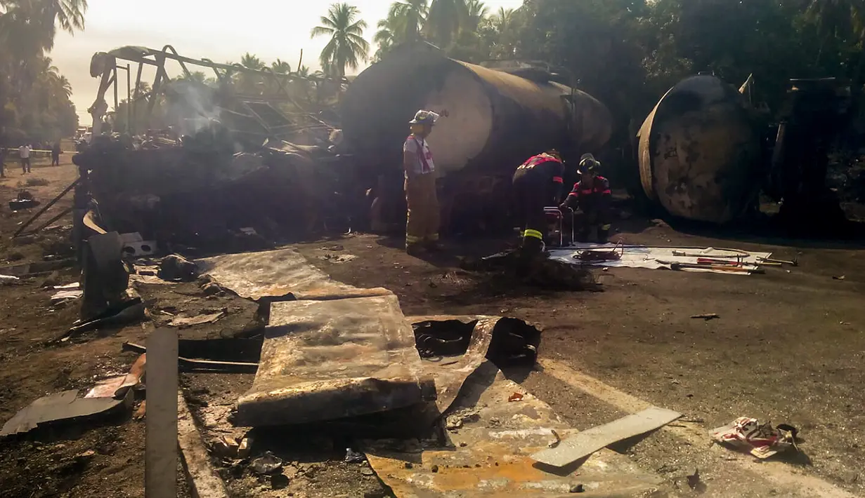 Petugas menyelidiki puing-puing bus dan truk tangki bahan bakar (BBM) yang bertabrakan di negara bagian Guerrero, Meksiko, Kamis (13/4). Tabrakan menimbulkan ledakan yang menewaskan 24 orang dan sembilan lainnya terluka. (HO/Guerrero Civil Protection/AFP)