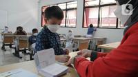 Murid kelas III menandatangani buku tabungan saat pembagian Tabungan Simpanan Pelajar (Simpel) di SDN Pondok Labu 07, Jakarta, Kamis (10/3/2022). Pembagian tabungan dalam rangka mendukung program OJK untuk kepemilikan rekening siswa One Student One Account. (merdeka.com/Arie Basuki)