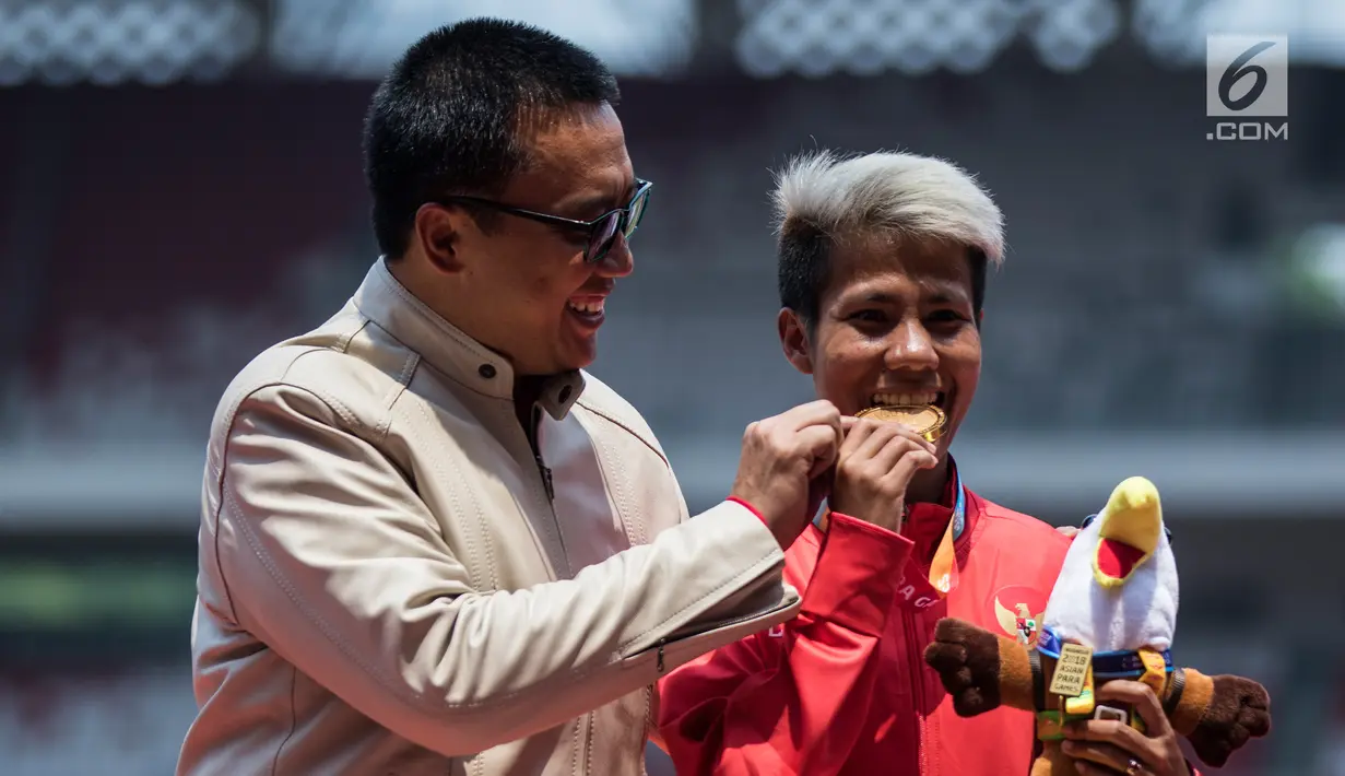 Atlet lompat jauh Indonesia, Rica Oktavia (kanan) foto bersama Menpora Imam Nahrawi usai meraih medali emas Asian Para Games 2018 di SUGBK, Jakarta, Senin (8/10). Rica menorehkan lompatan mencapai 5,25 meter. (Bola.com/Vitalis Yogi Trisna)