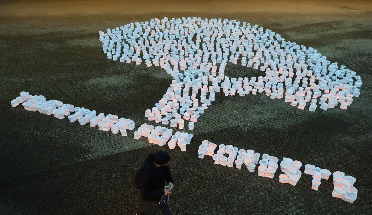 Seorang pejalan kaki berjalan melewati sebuah instalasi yang menyerukan perlindungan hutan di luar kantor pusat Komisi Eropa di Brussel, Belgia (14/12/2020). (Xinhua/Zheng Huansong)