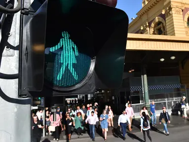 Lampu lalulintas bertanda perempuan menyala saat peringatan hari perempuan Internasional di Swanston Street dekat Stasiun Flinders Street, Melbourne, Australia, Rabu (8/3). Hal ini terkait peringatan Hari Perempuan Internasional. (AFP Photo / Paul Crock)
