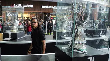 Legenda sepak bola Juventus Edgar Davids melihat-lihat trofi yang dipamerkan saat pembukaan Juventus Village di Lippo Mall Kemang, Jakarta Selatan, Jumat (27/1/2023). Juventus Village yang dibuka pada 27-29 Januari 2023 bakal memanjakan fans dengan beragam acara seperti meet and greet dengan Edgar Davids, pameran trofi dan replika ruang ganti hingga game-game menarik. (Liputan6.com/Faizal Fanani)