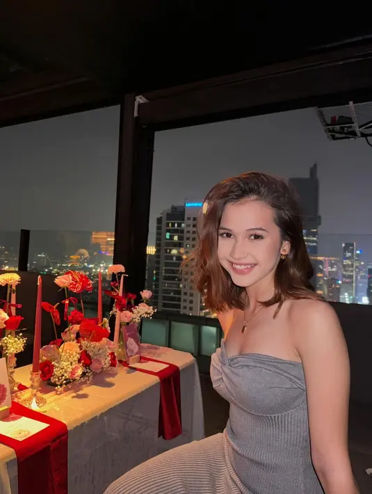 Sandrinna tampil memukau dalam balutan strapless dress abu-abu berbahan knit. Dress tersebut dipermanis dengan aksesori berupa kalung dan anting emas. [@sandrinna_11].