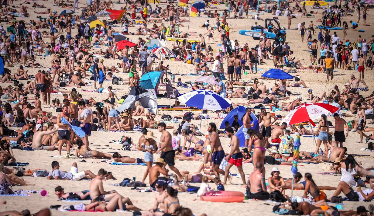 Orang-orang mengunjungi pantai Bondi di Sydney, Australia pada 5 Oktober 2020. Pengunjung ramai berjemur dan bermain di pantai dan berenang di laut saat pandemi Covid-19 masih berlangsung.  (Photo by DAVID GRAY / AFP)