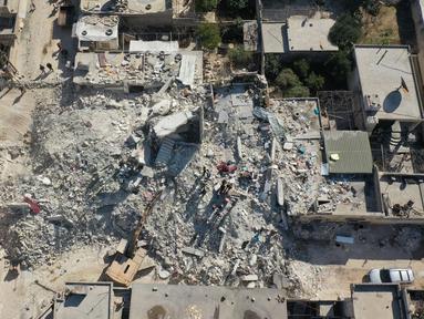 Sebuah foto udara menunjukkan puing-puing bangunan yang runtuh dan setengah runtuh di kota Jindayris, Suriah, Rabu (15/2/2023). Gempa bumi berkekuatan 7,8 magnitudo menghantam Turki dan Suriah pada 6 Februari lalu, menewaskan sedikitnya 40.000 orang serta menghancurkan sebagian besar wilayah Suriah dan Turki. (Omar HAJ KADOUR/AFP)