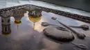 Sebuah batu nisan yang digenangi air menunjukan refleksi dari kubah emas Biara Orthodok Yerusalem Baru yang terletak di luar kota Istra, Rusia (21/10). Bangunan ini dibangun untuk mewakili situs Yerusalem Suci. (AFP Photo/Mladen Antonov)