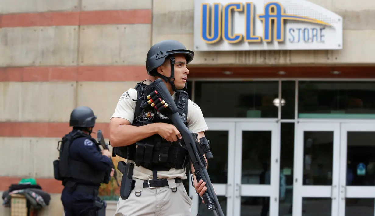 Seorang petugas bersenjata laras panjang mengamankan Universitas California Los Angeles (UCLA) di California, Rabu (1/6). UCLA ditutup sementara setelah terjadi penembakan di satu laboratorium teknik yang menewaskan dua orang. (REUTERS/Patrick T. Fallon)