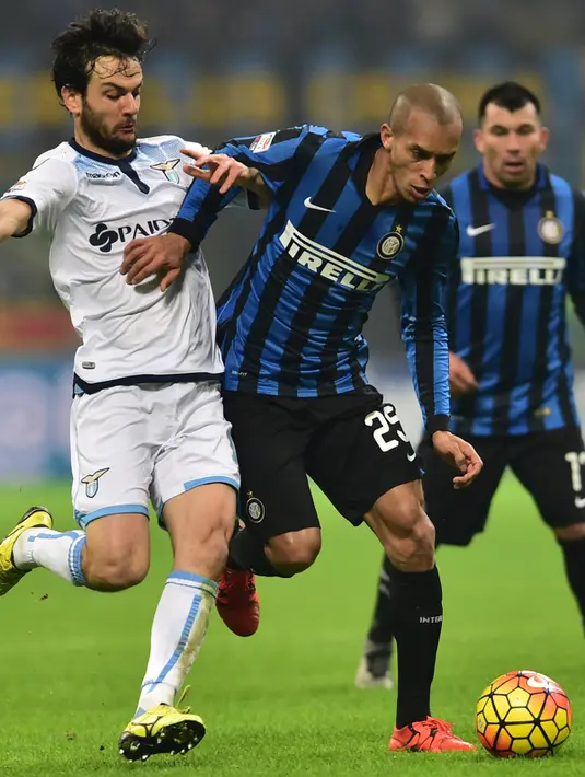 Bek Inter Milan, Joao Miranda (tengah) berusaha membawa bola dari kejaran gelandang Lazio, Marco Parolo pada lanjutan liga Italia di Stadion San Siro, Italia (20/12). Lazio menang atas Inter Milan dengan skor 2-1. (AFP/GIUSEPPE CACACE)