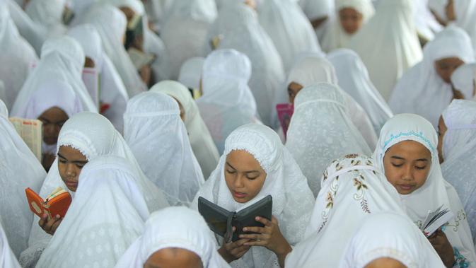 Puluhan santri membaca Al Quran saat tadarus massal awal Ramadhan 1440 H di Pesantren Ar-Raudhatul Hasanah, Medan, Sumatera Utara pada 6 Mei 2019. Tadarus yang diikuti sedikitnya 3.200 santri tersebut merupakan kegiatan rutin selama bulan Ramadan di pesantren tersebut. (RAHMAD SURYADI / AFP)