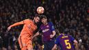 Duel udara antara Lucas Tousart dan Sergi Roberto pada leg kedua, babak 16 besar Liga Champions yang berlangsung di Stadion Camp Nou, Barcelona, Kamis (14/3). Barcelona menang 5-1 atas Lyon. (AFP/Josep Lago)