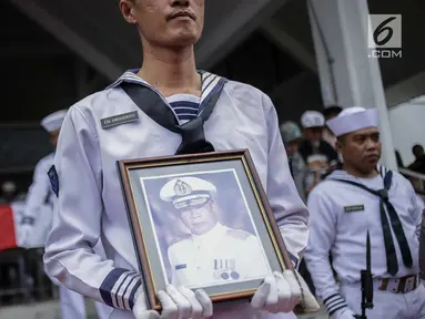 Prajurit TNI AL membawa foto almarhum Amoroso Katamsi setelah disalatkan di Masjid Imam Bonjol, Pondok Labu, Jakarta, Senin (17/4). Upacara pemakaman pemeran Presiden Soeharto di film G30S/PKI itu dilakukan secara militer. (Liputan6.com/Faizal Fanani)