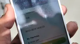 Juru parkir menunjukkan aplikasi untuk mendata kendaraan di Kelapa Gading, Jakarta, Rabu (30/1). Parkir online berbasis aplikasi menggantikan parkir meter yang sebelumnya telah diluncurkan untuk mendukung program Smart City. (Merdeka.com/Iqbal S Nugroho)