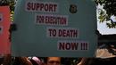 Pegiat Granat membawa poster bertuliskan "Support for Execution to Death Now!!!" saat menggelar aksi  demonstrasi di depan pintu masuk Dermaga Wijaya Pura, Cilacap, Jateng, Jumat (6/3). (Liputan6.com/Johan Tallo)