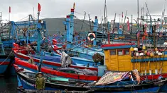 Seorang wanita memandang dari perahu kecil saat orang-orang mempersiapkan kapal penangkap ikan untuk menghadapi dampak Topan Kalmaegi di Pelabuhan Ikan Quy Nhon, Provinsi Gia Lai, Vietnam Tengah, pada 6 November 2025. (Nhac NGUYEN/AFP)