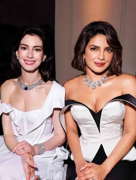 Detail shirtdress yang dikenakan Anne Hathaway ini memiliki salah satu bahu telanjang dan lengan bajunya jatuh dari bahu ke lekukan sikunya. [Foto: Instagram/bvlgari]