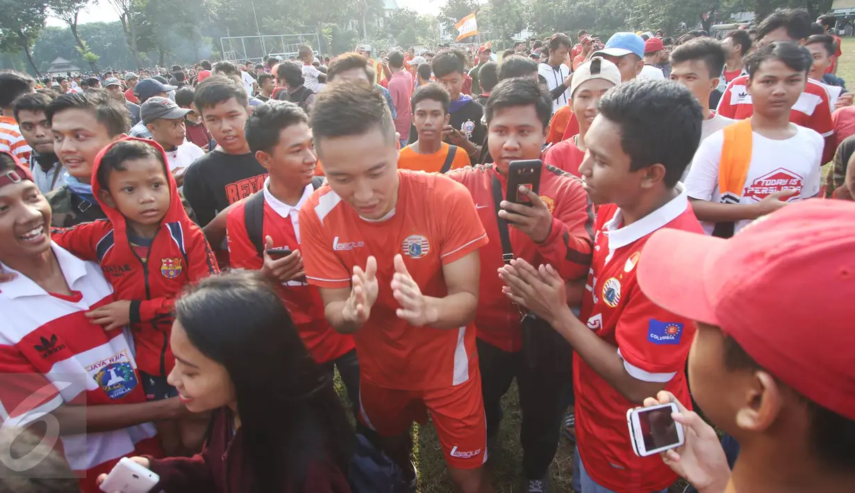 Pemain klub Persija Jakarta dikerumuni pendukung The Jakmania usai melakukan latihan di Lapangan Banteng, Jakarta, Selasa (11/4). (Liputan6.com/Immanuel Antonius)