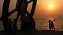 Turis mengabadikan gambar saat matahari tenggelam atau sunset di pinggir laut, Pulau Kish, Iran, 1 November 2016. Kish sudah menarik 1,8 juta pengunjung per tahun, dari 2,2 juta pada 2009 menjadi 5,2 juta pada 2015. (Atta Kenare/AFP)