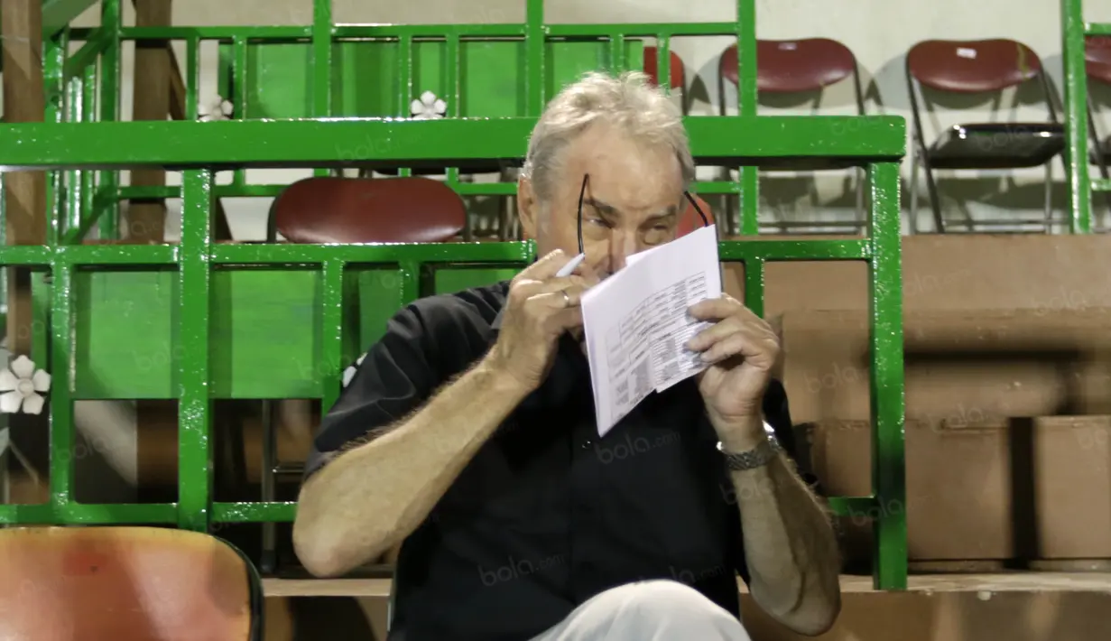 Dengan kacamatanya Alfred Riedl yang lahir di Wina, Austria, 2 November 1949  bersiap memantau calon pemain timnas Indonesia di Stadion Tridarma Gresik, Minggu (12/6/2016).  (Bola.com/Nicklas Hanoatubun)