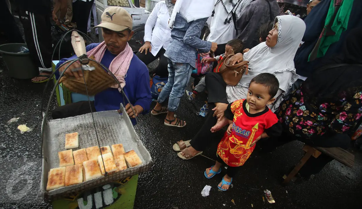 Peserta aksi damai 2 Desember membeli makanan di sekitar Mesjid Istiqlal, Jakarta, Jumat (2/12). Aksi 2 Desember yang dipenuhi massa menjadi kesempatan bagi sejumlah PKL untung meraup untung. (Liputan6.com/Immanuel Antonius)