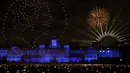 Orang-orang menonton tampilan lampu drone yang menampilkan mantan Ratu Elizabeth II Inggris dan kembang api dari Horse Guards Parade di pusat kota London untuk merayakan Tahun Baru pada Minggu, 1 Januari 2023. (AP Photo/David Cliff)