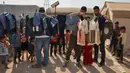 <p>Sukarelawan membagikan pakaian kepada anak-anak Suriah di sebuah kamp di pinggiran kota Dana yang dikuasai pemberontak, di sebelah timur perbatasan Turki-Suriah di provinsi barat laut Idlib (30/4/2022). Umat Islam seluruh dunia bersiap untuk merayakan Idul Fitri yang menandai akhir bulan puasa Ramadhan. (AFP/Aaref Watad)</p>
