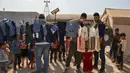 <p>Sukarelawan membagikan pakaian kepada anak-anak Suriah di sebuah kamp di pinggiran kota Dana yang dikuasai pemberontak, di sebelah timur perbatasan Turki-Suriah di provinsi barat laut Idlib (30/4/2022). Umat Islam seluruh dunia bersiap untuk merayakan Idul Fitri yang menandai akhir bulan puasa Ramadhan. (AFP/Aaref Watad)</p>