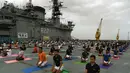Sejumlah Personel Angkatan Laut India saat mengikuti yoga bersama menandai Hari Yoga Internasional di atas kapal induk INS Viraat di pelabuhan Mumbai, India, (21/6). Olahraga yoga telah menyatukan dunia dengan India. (AFP Photo/Punit Paranjpe)