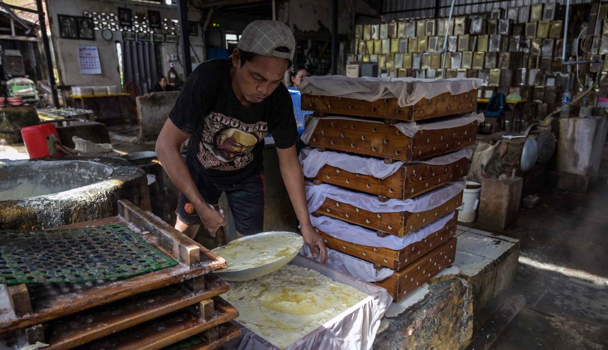Seorang pekerja menyaring kedelai giling yang sudah dimasak untuk mendapatkan ekstraknya di sebuah pabrik tahu, Surabaya, Jawa Timur pada Kamis 5 Februari 2026. (JUNI KRISWANTO/AFP)