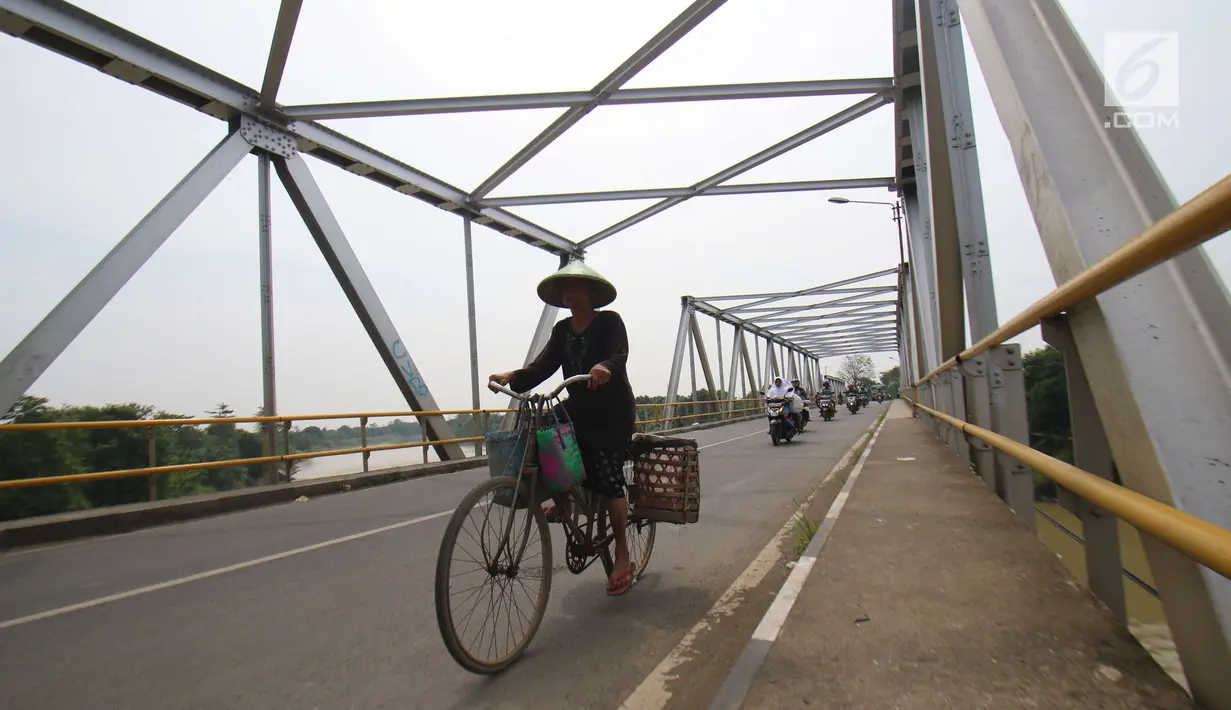 Pengendara sepeda melintasi jembatan Bangkir Indramayu, Jawa Barat, Jumat (30 /6). H+5 Indramayu Kota ke Arah Jakarta melalui Jalur Utara diprediksi mulai di padati arus balik pada Malam dan esok hari H+6. (Liputan6.com/Helmi Afandi)