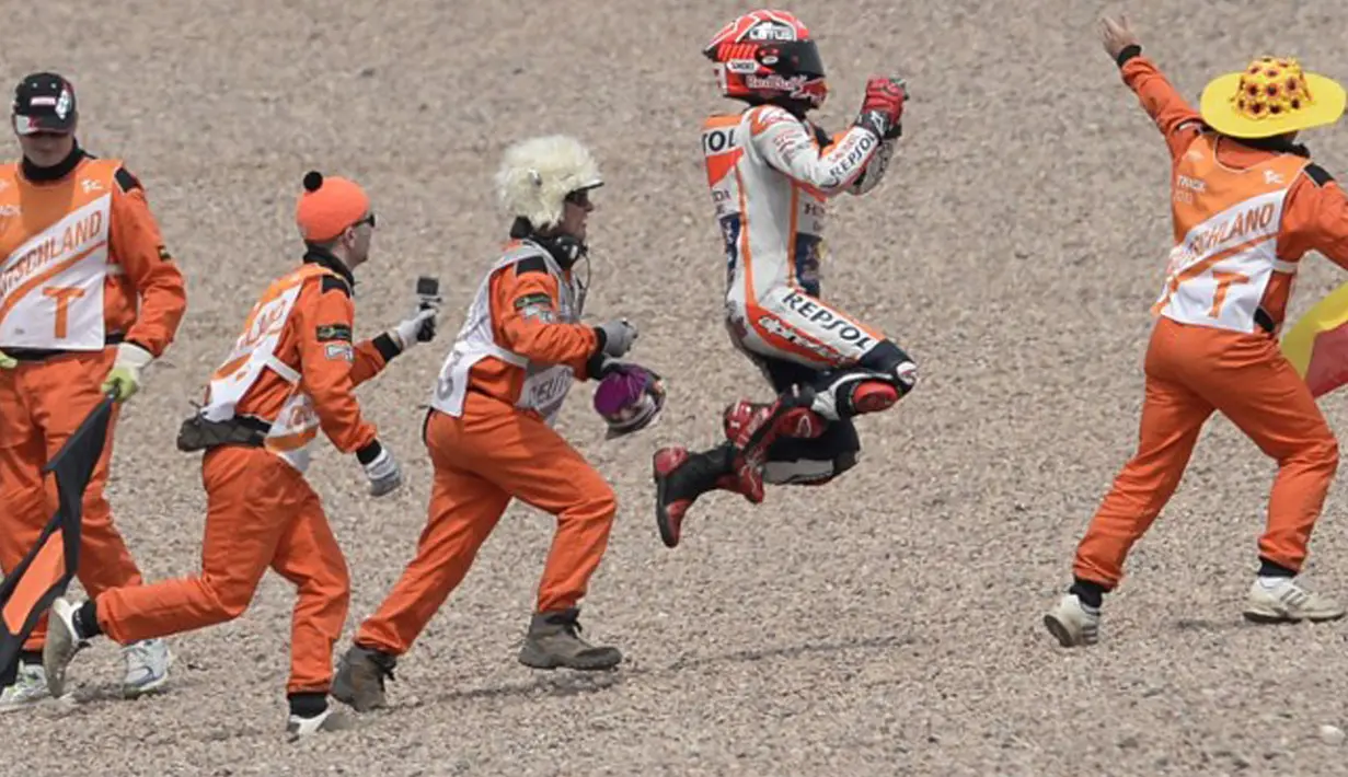 Pembalap Spanyol Tim Repsol Honda Marc Marquez mengekspresikan kebahagiaanya bersama fans di Sirkuit Sachsenring, Jerman, Minggu (12/7/2015). Pembalap kelahiran 1993 ini sudah dua kali juara pada gelaran motoGP. (AFP PHOTO/Robert Michael)