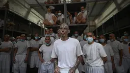 Di kompleks penjara di Tecoluca, sebelah tenggara ibu kota San Salvador, puluhan narapidana dengan kepala plontos mengintip dari satu blok sel. (Marvin RECINOS / AFP)