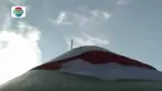 Upaya menaikkan bendera raksasa ini sedikit terkendala karena tiupan angin kencang.
