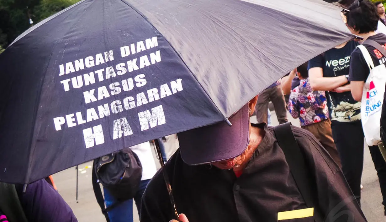 Dalam aksinya, mereka membawa payung hitam bertuliskan tuntutan, Jakarta, (4/9/14). (Liputan6.com/Faizal Fanani)