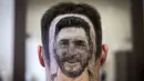 Seorang penggemar menunjukkan tato rambut wajah Lionel Messi di sebuah salon rambut di Serbia, 10 Juni 2018. Sang penata rambut memberi masukan kepada pelanggannya untuk melakukan sesuatu yang berbeda jelang Piala Dunia 2018. (AFP/VLADIMIR ZIVOJINOVIC)