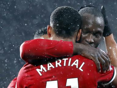 Striker Manchester United, Romelu Lukaku, memeluk Anthony Martial usai mencetak gol  ke gawang AFC Bournemouth pada laga Premier League di Stadion Old Trafford, Rabu(13/12/2017). Manchester United menang 1-0 atas AFC Bournemouth. (AP/Martin Rickett)