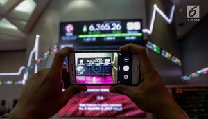 Pengunjung mengambil foto layar indeks harga saham gabungan yang menunjukkan data di Bursa Efek Indonesia, Jakarta, Selasa (2/1). Sebelumnya, Perdagangan Indeks Harga Saham Gabungan (IHSG) 2017 ditutup pada level 6.355,65 poin.(Liputan6.com/Faizal Fanani)
