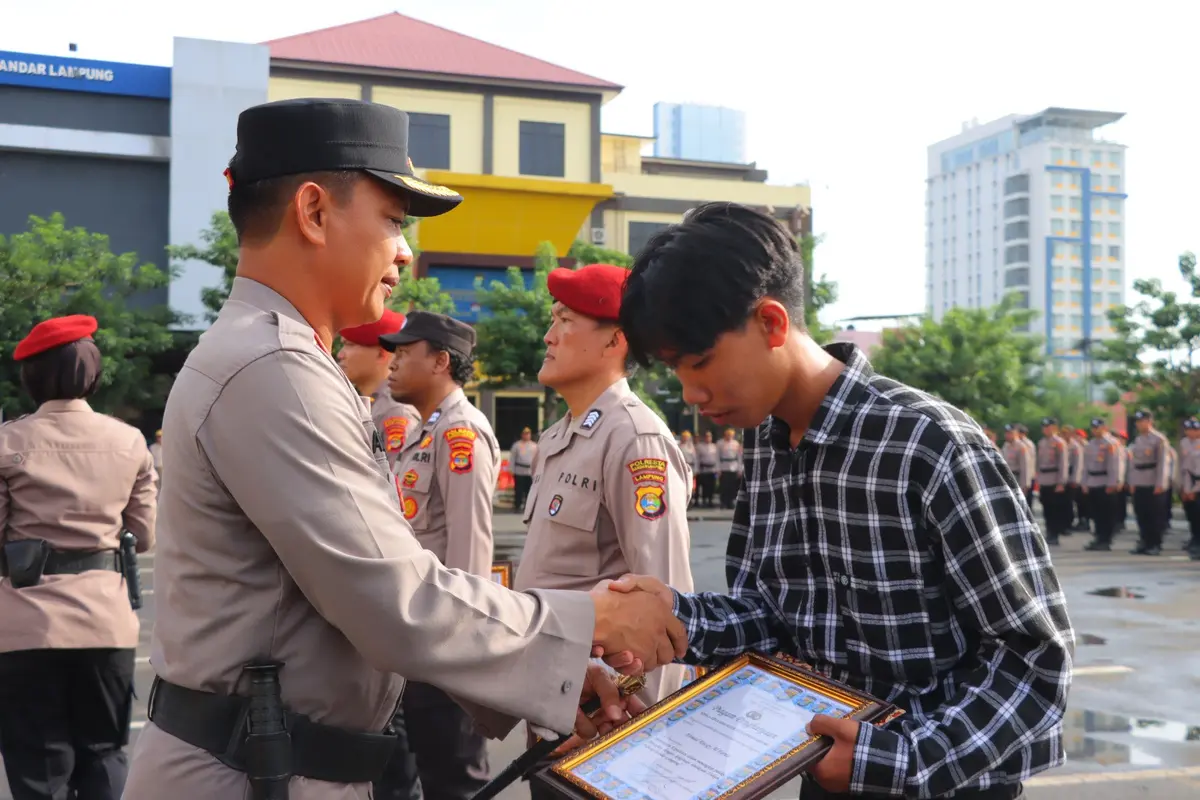 Ahmad Razky mendapat penghargaan dari Kapolresta Bandar Lampung, Kombes Pol Abdul Waras karena berhasil menggagalkan aksi pencurian. Foto : (Polresta Bandar Lampung)