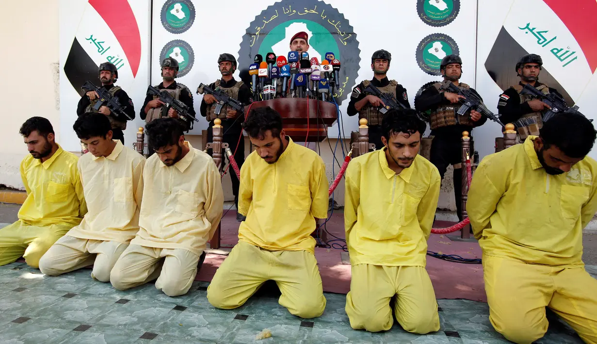 Sejumlah pria yang diduga sebagai militan ISIS bersama dengan sejumlah senjata api saat dihadirkan dalam rilis media yang digelar militer Irak di Baghdad, (7/9). Militan ISIS ditangkap hidup-hidup oleh Militer Irak. (REUTERS/Khalid al Mousily)