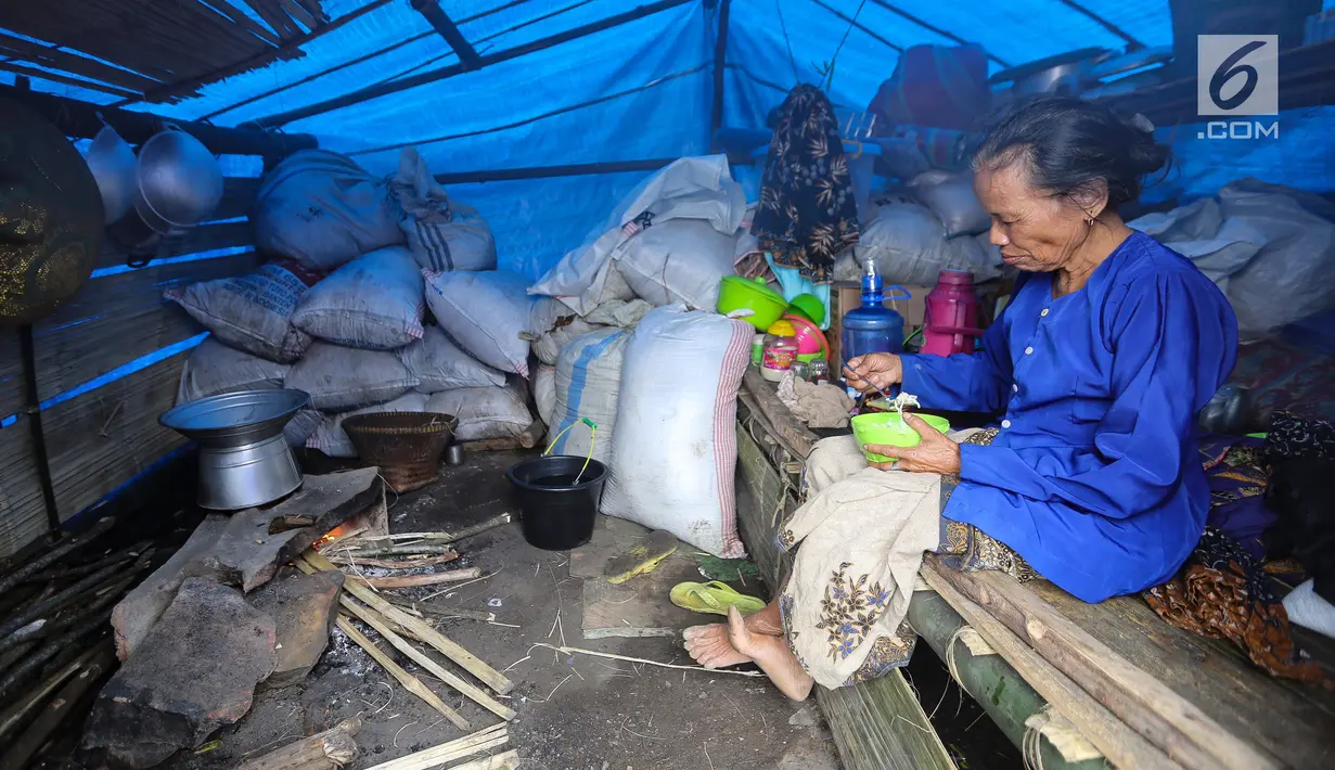 Seorang nenek makan di dalam rumah yang dibangun dengan tenda di Kampung Cisaban II, Desa Kanekes, Banten, Kamis (01/6). Warga Baduy Luar mendapat bantuan dari Kemensos untuk membangun rumah mereka yang terbakar. (Liputan6.com/Fery Pradolo)