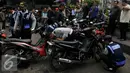 Petugas Dishub, mencabut pentil sebuah sepeda motor yang nekat parkir liar di Jakarta, Jumat (12/6/2015). Razia gabungan Dishub, Garnisun dan Satlantas bertujuan untuk mengantisipasi arus lalu lintas yang kerap macet. (Liputan6.com/Johan Tallo)