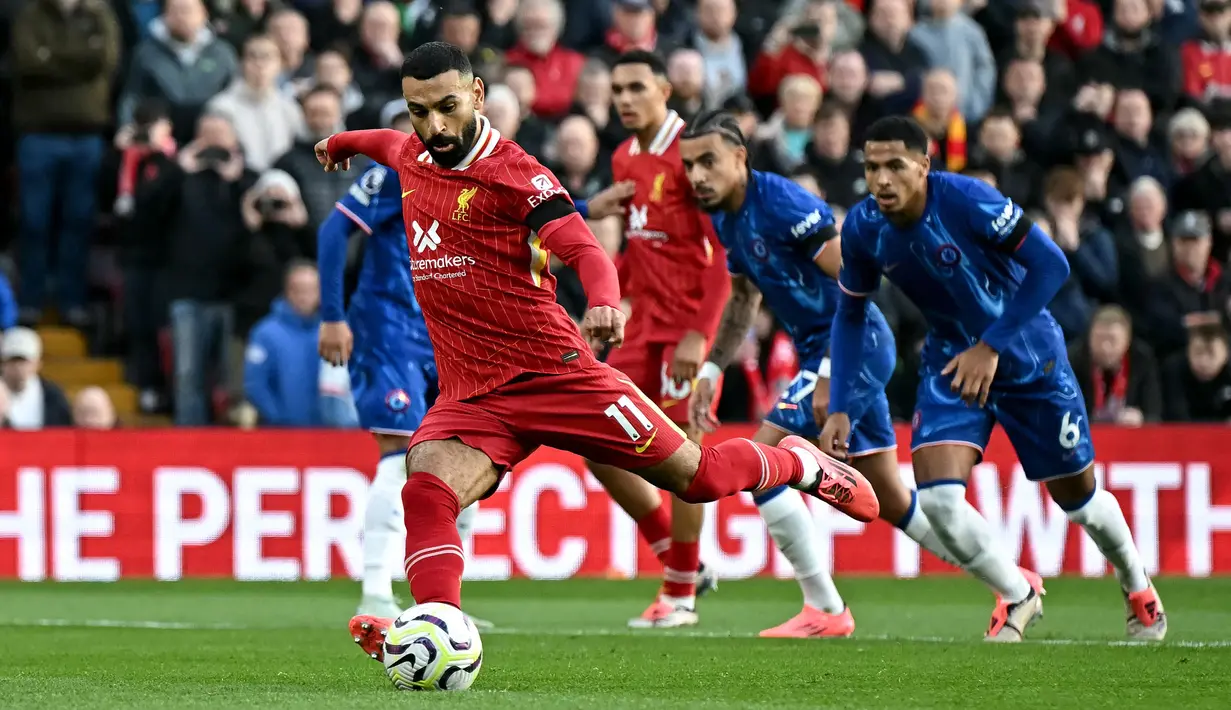 Pemain Liverpool, Mohamed Salah mencetak gol melalui eksekusi tendangan penalti pada laga lanjutan Liga Inggris 2024/2025 melawan Chelsea di Anfield, Liverpool, Inggris, Minggu (20/11/2024). (AFP/Paul Ellis)