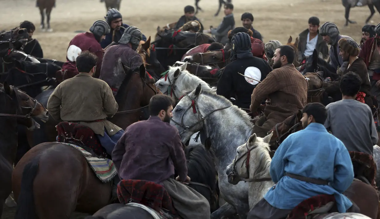 Penunggang kuda saat mengikuti pertandingan persahabatan buzkashi di pinggiran Kabul, Afghanistan, Jumat (27/12/2019). Buzkashi adalah olahraga tradisional Afghanistan di mana para pemainnya berlomba untuk menempatkan bangkai kambing ke dalam lingkaran. (AP Photo/Rahmat Gul)