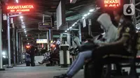 Penumpang menunggu kedatangan KRL di Stasiun Manggarai, Jakarta, Selasa (12/1/2021). Selama PSBB di DKI mulai 11-25 Januari, PT Kereta Commuter Indonesia (KCI) memangkas jadwal operasional KRL menjadi pukul 04.00 WIB hingga 22.00 WIB guna menekan penularan Covid-19. (merdeka.com/Iqbal Nugroho)