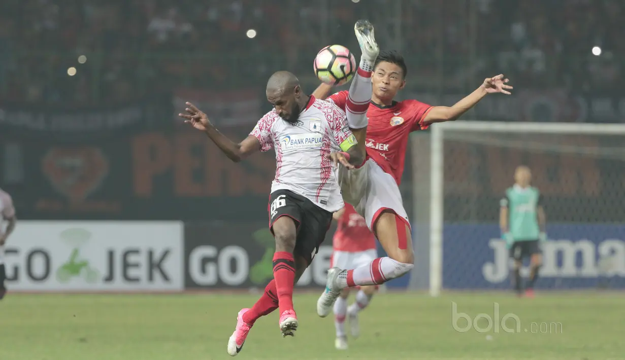 Duel pemain Persipura, Boaz Solossa dan pemain Persija Jakarta, Vava Mario Yagalo pada lanjutan Liga 1 2017 di Stadion Patriot, Bekasi, Sabtu (08/7/2017). Persija bermain imbang 1-1.  (Bola.com/Nicklas Hanoatubun)