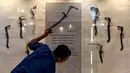 Seorang pekerja membersihkan etalase yang memajang rencong jelang pameran persenjataan tradisional di Museum Aceh, Banda Aceh, Aceh, Jumat (15/10/2021). Museum Aceh menggelar Pameran Senjata 2021 dengan mengangkat tema “Semangat, Simbol, dan Identitas". (CHAIDEER MAHYUDDIN/AFP)
