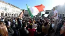 Suporter Juventus mengibarkan bendera Itali merayakan kemenangan usai merebut gelar Serie A Italia di pusat kota Turin, Italia (25/4). Juventus sukses meraih lima gelar juara Serie A dalam lima musim beruntun. (REUTERS/Giorgio Perottino) 
