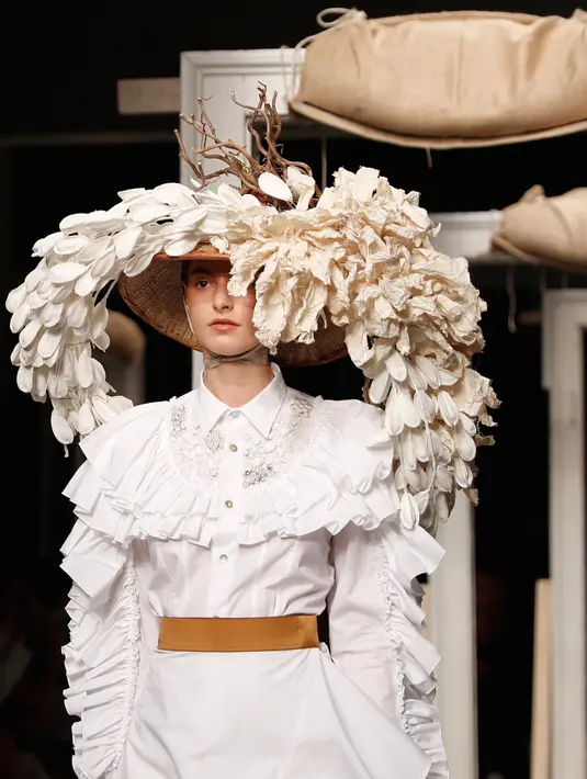 Model mengenakan topi dan hiasan kepala unik saat memeragakan koleksi Musim Semi-Musim Panas 2019 di Milan Fashion Week, Milan, Italia, Jumat (21/9). Hiasan kepala mulai dari tumbuhan hingga kupu-kupu. (AP Photo/Antonio Calanni)