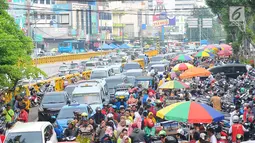 Sejumlah mobil terjebak kemacetan di kawasan Tanah Abang, Jakarta, Minggu (26/5/2019). Banyaknya masyarakat yang berbelanja di pasar tanah abang membuat arus lalu lintas di kawasan tersebut padat. (Liputan6.com/Angga Yuniar)