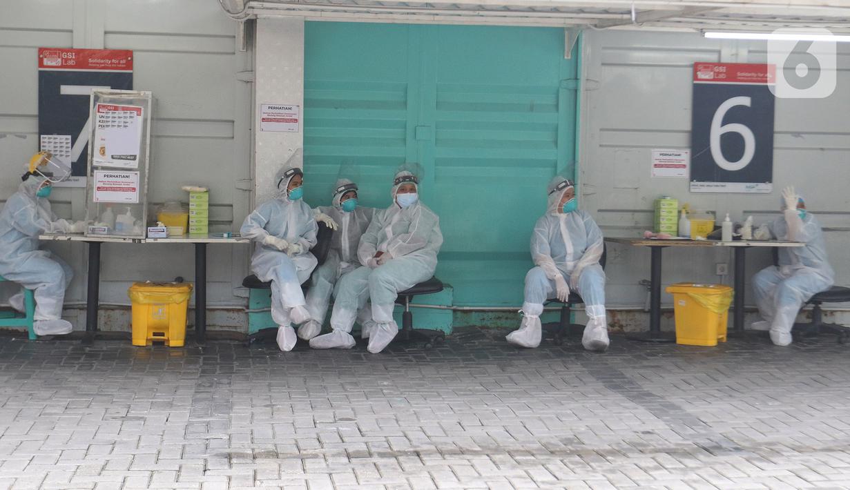 Petugas kesehatan beristirahat sambil menunggu warga yang akan melakukan tes usap (swab test) PCR di Jakarta, Senin (25/10/2021). Presiden Joko Widodo atau Jokowi mengarahkan untuk menurunkan harga tes PCR menjadi Rp300 ribu dan masa berlaku diperpanjang 3x24 jam.  (Liputan6.com/Herman Zakharia)